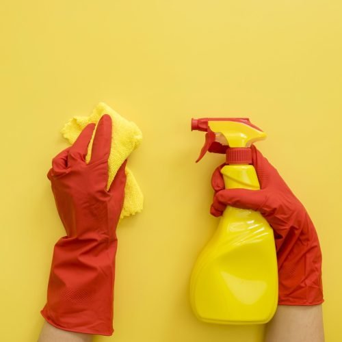 top-view-hands-with-rubber-gloves-holding-cleaning-supplies